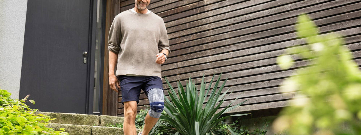 GenuTrain knee support worn while walking down garden steps: knee support for osteoarthritis - Bauerfeind UK