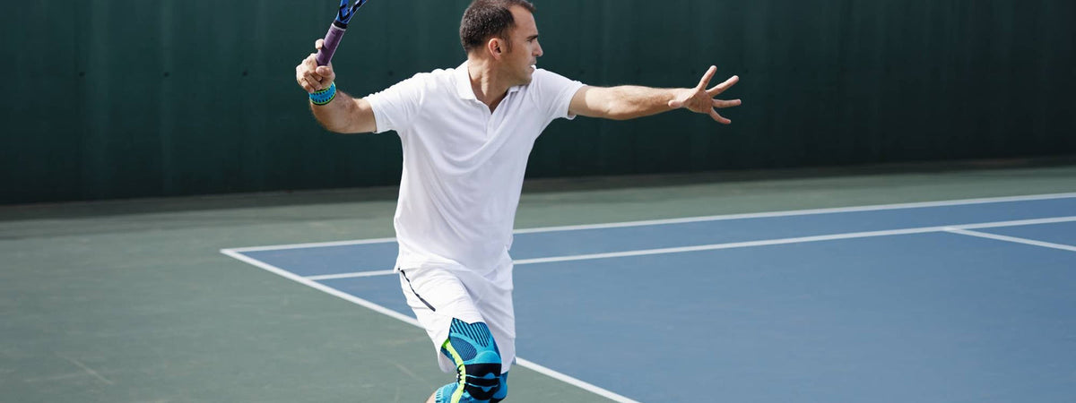 Tennis player wearing a Bauerfeind sports knee support and wrist strap: how to manage tennis elbow - Bauerfeind UK