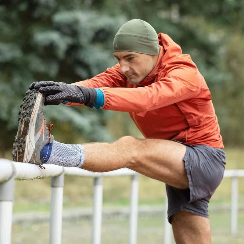 Man stretching his leg on a railing while wearing an AchilloTrain support